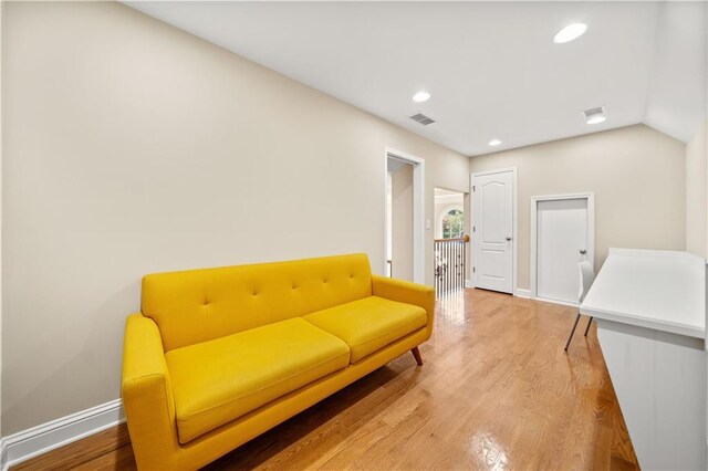 living area with hardwood / wood-style floors and vaulted ceiling