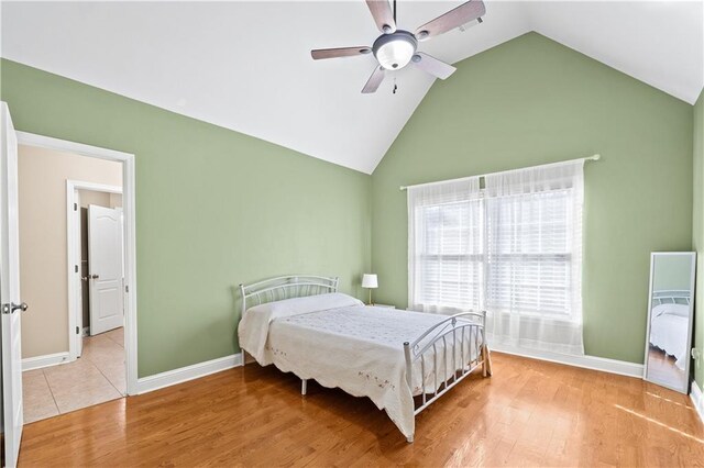 bedroom with high vaulted ceiling, light hardwood / wood-style flooring, and ceiling fan