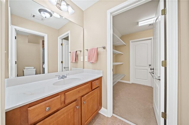 bathroom featuring tile patterned flooring, vanity, and toilet