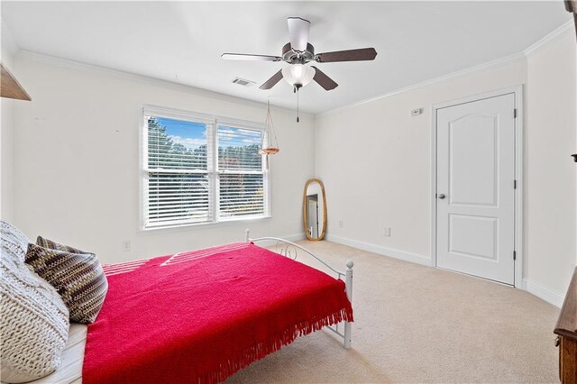 carpeted bedroom featuring ceiling fan and crown molding