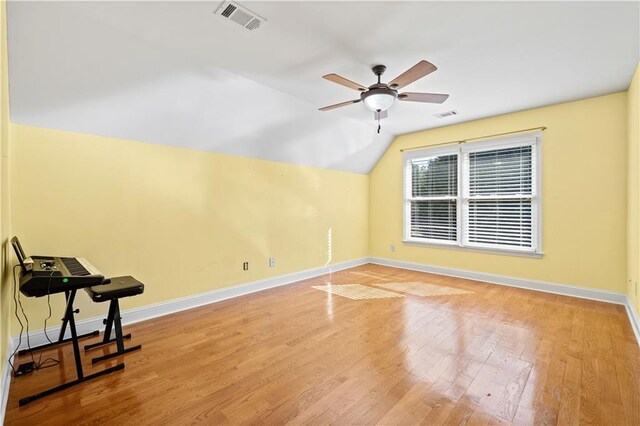 additional living space with hardwood / wood-style floors, vaulted ceiling, and ceiling fan