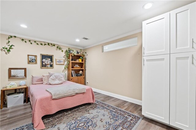 bedroom featuring light hardwood / wood-style floors and ornamental molding