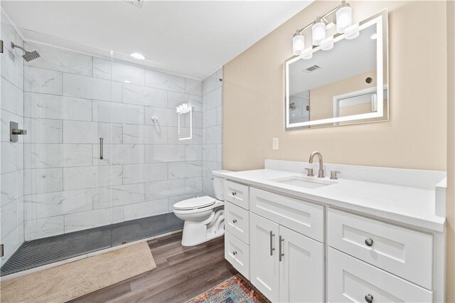 bathroom featuring walk in shower, vanity, wood-type flooring, and toilet