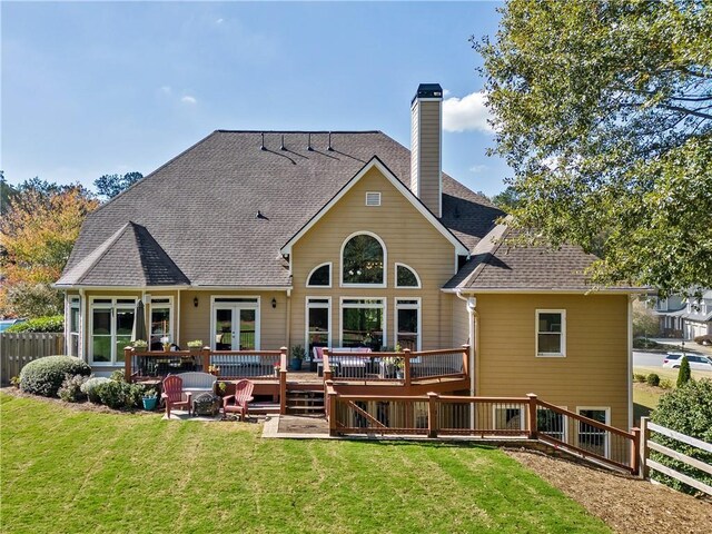 rear view of property featuring a lawn and a wooden deck