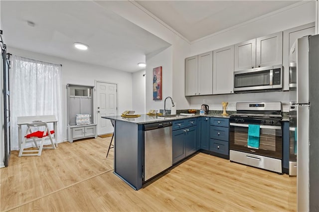 1463 Metropolitan Pkwy SW, Atlanta, GA 30310 - kitchen with stainless steel appliances, a sink, a peninsula, light wood-style flooring, and a kitchen breakfast bar