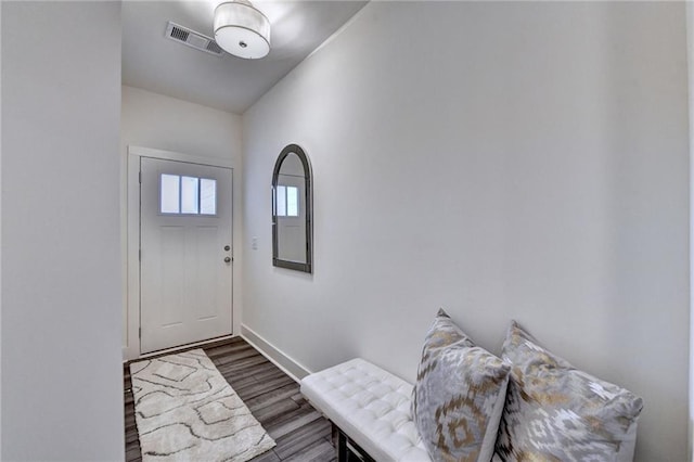 doorway featuring dark wood finished floors, visible vents, and baseboards