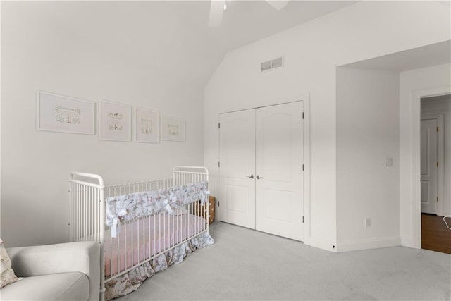 bedroom featuring carpet, a closet, lofted ceiling, baseboards, and ceiling fan