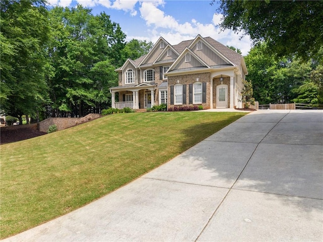 view of front of house featuring driveway, covered porch, and brick siding