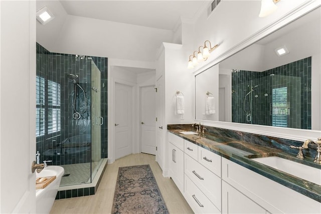 full bath featuring a stall shower, wood finished floors, double vanity, and a soaking tub