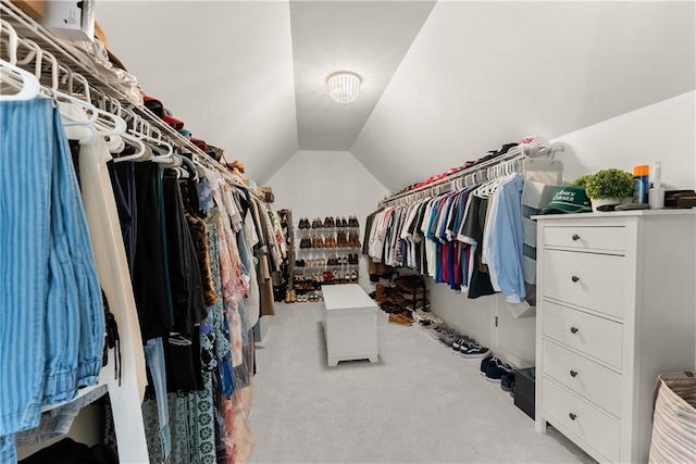 walk in closet featuring light colored carpet and lofted ceiling