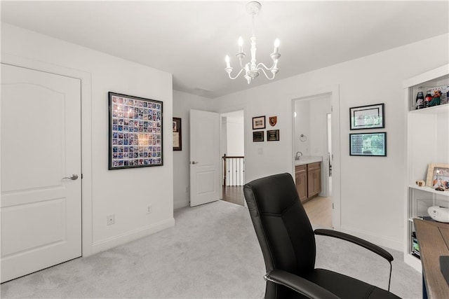 home office with light carpet, a chandelier, baseboards, and a sink