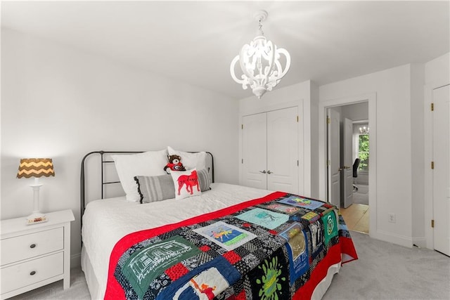 bedroom with a chandelier, light colored carpet, a closet, and baseboards