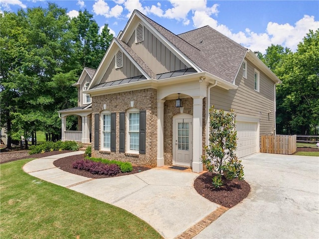 craftsman-style house featuring board and batten siding, driveway, fence, roof with shingles, and an attached garage
