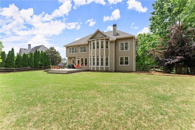 rear view of property with a chimney and a deck