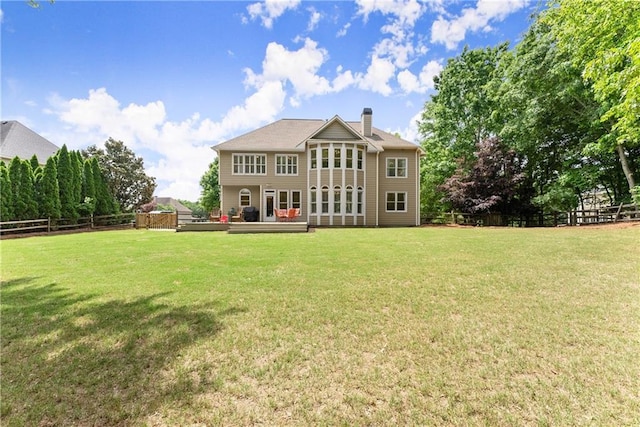 rear view of property featuring a chimney and a deck
