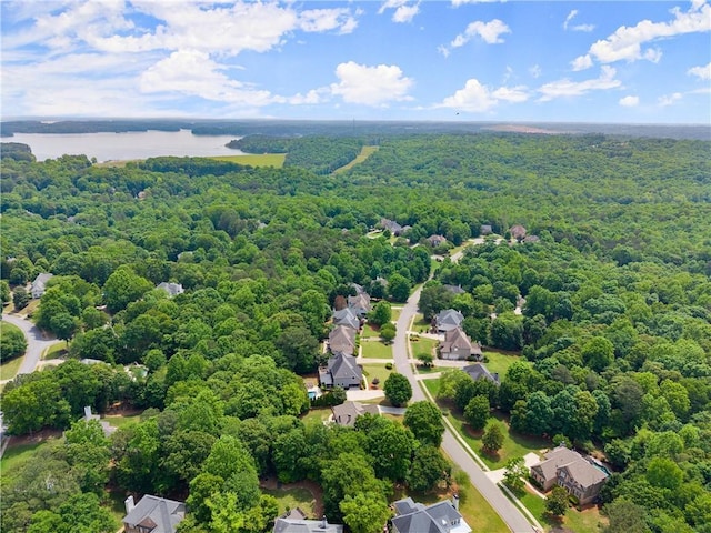 drone / aerial view of a heavily wooded area and a nearby body of water