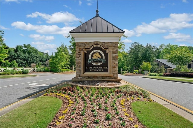 community sign featuring view of wooded area
