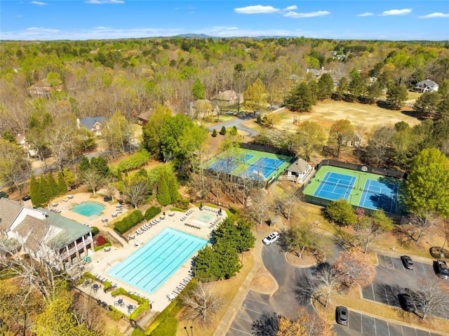 aerial view of a pool and a heavily wooded area