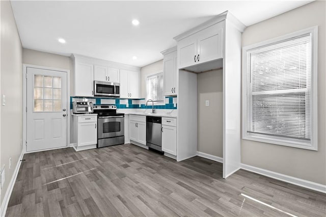 4064 Post Rd, Winston, GA 30187 - kitchen with white cabinets, stainless steel appliances, light wood finished floors, and light countertops