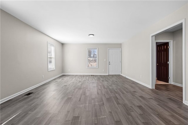 4064 Post Rd, Winston, GA 30187 - unfurnished living room with baseboards, visible vents, dark wood-style flooring, and a wealth of natural light