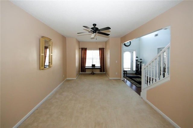 unfurnished living room with ceiling fan and light carpet