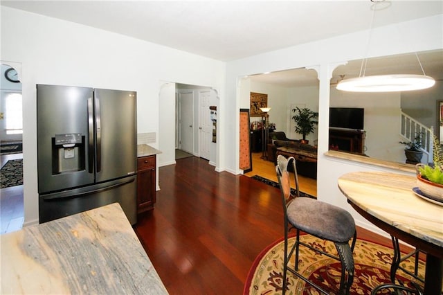 dining area with dark wood-type flooring and ornate columns