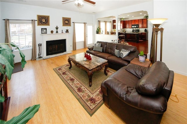 living room featuring light hardwood / wood-style flooring and ceiling fan