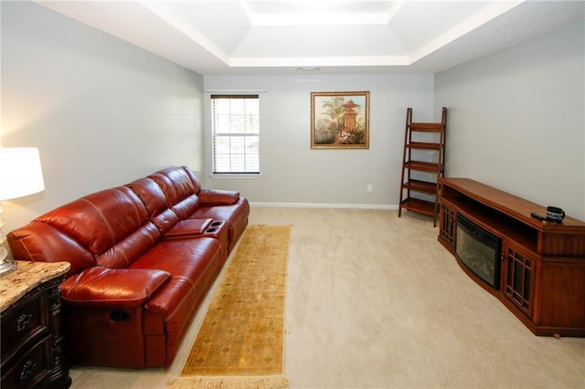 carpeted living room with a tray ceiling