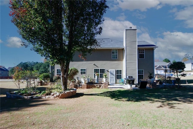 rear view of house featuring a lawn