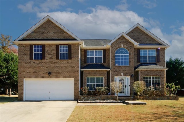 view of front of property with a garage and a front lawn