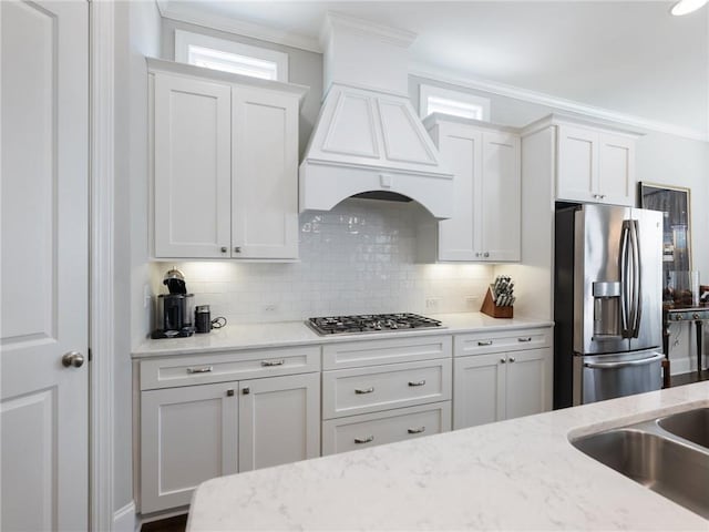 kitchen featuring light stone counters, stainless steel appliances, and white cabinets