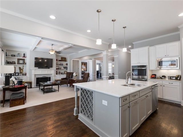 kitchen featuring appliances with stainless steel finishes, an island with sink, white cabinetry, hanging light fixtures, and coffered ceiling