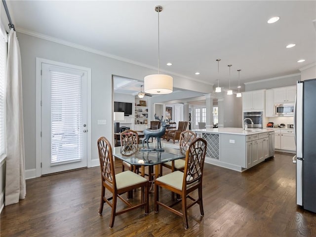 dining room with crown molding, ceiling fan, dark hardwood / wood-style floors, and decorative columns