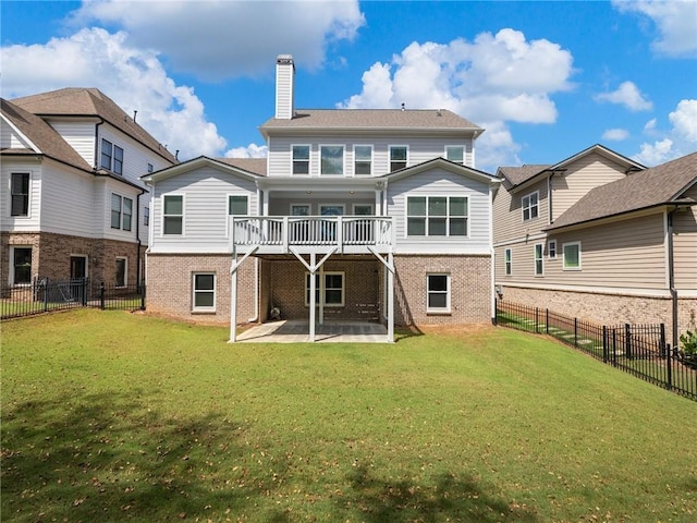 rear view of house featuring a wooden deck, a patio, and a lawn