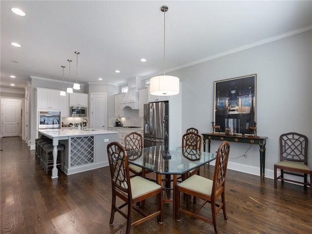 dining space with crown molding, sink, and dark hardwood / wood-style flooring