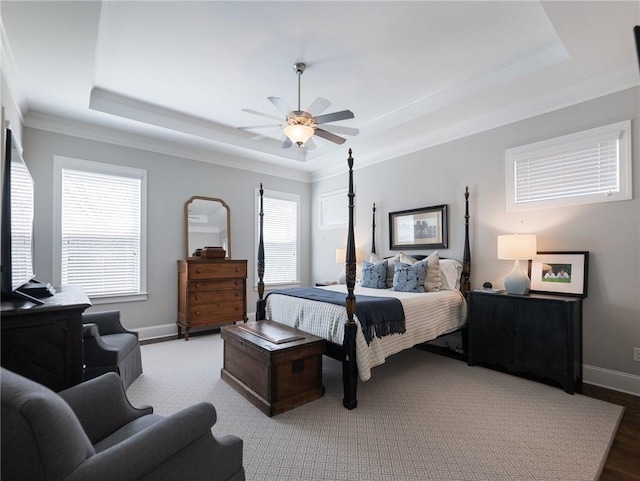 bedroom with crown molding, ceiling fan, and a tray ceiling