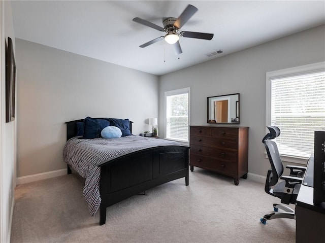 carpeted bedroom with ceiling fan and multiple windows