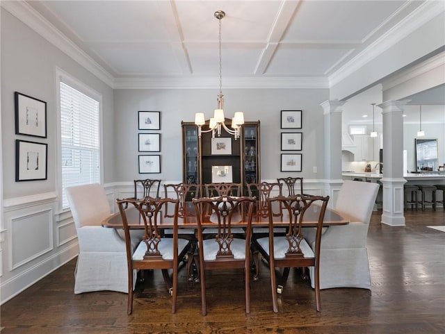 dining area featuring crown molding, a notable chandelier, dark hardwood / wood-style floors, and ornate columns