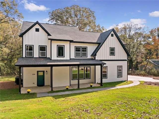 rear view of property with a lawn and a patio