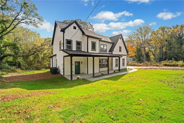 back of property featuring central AC unit and a lawn