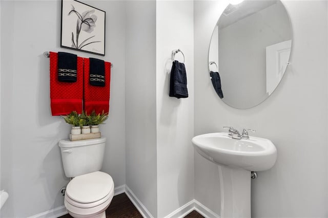 bathroom featuring hardwood / wood-style flooring, sink, and toilet