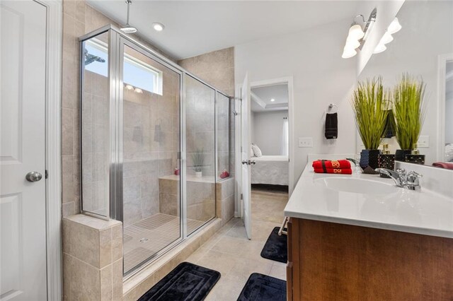 bathroom featuring tile patterned floors, a shower with door, and vanity