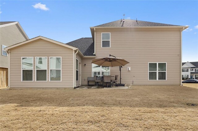 rear view of property featuring a yard and a patio area