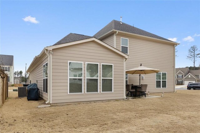 rear view of house with a lawn and a patio