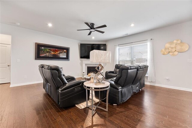 living room featuring ceiling fan and dark hardwood / wood-style floors