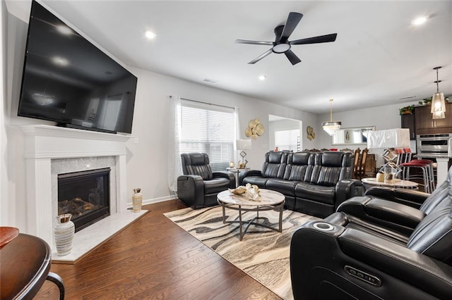 living room featuring ceiling fan, dark hardwood / wood-style floors, and a high end fireplace