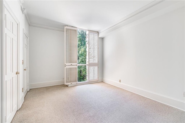 spare room featuring crown molding and light colored carpet