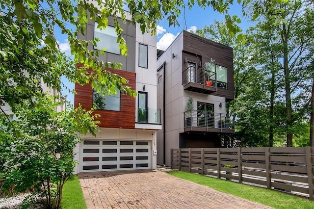 167 Sampson St NE, Atlanta, GA 30312 - view of front of house with decorative driveway, a garage, a balcony, and stucco siding
