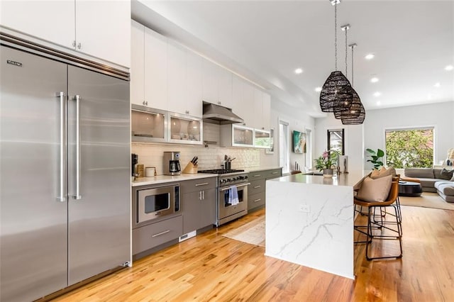 167 Sampson St NE, Atlanta, GA 30312 - kitchen with built in appliances, under cabinet range hood, light wood-type flooring, recessed lighting, and backsplash