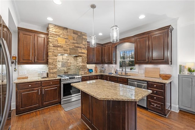 kitchen featuring stainless steel appliances, dark hardwood / wood-style floors, hanging light fixtures, a kitchen island, and sink